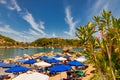 In a bay on the beautiful island of Rhodes, holidaymakers relax under parasols