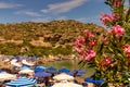 In a bay on the beautiful island of Rhodes, holidaymakers relax under parasols