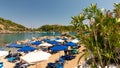 In a bay on the beautiful island of Rhodes, holidaymakers relax under parasols