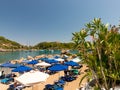 In a bay of Rhodes, holidaymakers relax under parasols
