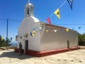 Rhodes, Greece - July 17, 2018: Beautiful view of the small white church on the island of Rhodes. Multi-colored flags hang near Royalty Free Stock Photo