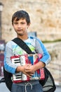 Portrait of a boy accordion player holding his accordion standing outdoors at the waterfront of Rhodes, Greece Royalty Free Stock Photo