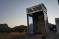 An old payphone booth without a payphone set. A payphone is typically a coin-operated public telephone. Kolympia, Rhodes, Greece Royalty Free Stock Photo