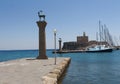 Rhodes Mandraki harbor with castle and symbolic deer statues, Greece