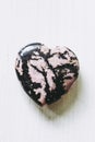 Rhodonite stone heart on a white background Royalty Free Stock Photo