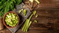 Rhubarb on wooden table. Fresh rhubarb in bowl. Stems and leaves of fresh rhubarb. Long banner format. Copy space for text