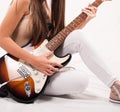 Rhythm and Melody: Young Woman Captivating with her Guitar - Close-Up Studio Shot