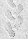 Rhythmic boot prints on thin white snow in winter recede into the distance, vertical frame, ribbed protector, winter concept Royalty Free Stock Photo