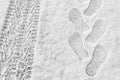 Rhythmic footprints, boot tracks and car tires on thin white snow in winter go into the distance, horizontal frame, ribbed tread, Royalty Free Stock Photo