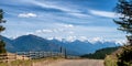 Fencing along a rural road frame Rocky Mountains in Canada