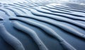 Rhythmic patterns carved by the tide create a beautiful texture on a tranquil, wet sand beach. Royalty Free Stock Photo