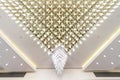 Rhythmic texture on suspended ceiling with rows of halogen spots lamps and drywall construction with chandelier. Stretch ceiling
