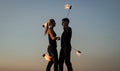 Rhythmical swinging. Couple of dancers swing burning poi blue sky. Fiery poi swinging. Fire performance. Fun and Royalty Free Stock Photo