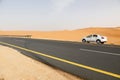 Riad, Saudi Arabia, February 16 2020: Typical road in Saudi Arabia that leads through the desert. There is a white car on the road