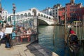 Tourists have lunch at the cafe terrace with a view to the landmark Ponte di Rialto bridge over the Grand Canal in Venice, Italy. Royalty Free Stock Photo