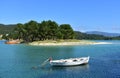 Beach with turquoise water, pine trees and fishing boats. Galicia, Spain.