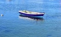 Old blue wooden small boat floating on the sea at famous Rias Baixas in Galicia Region. Spain.