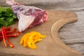 Rib chop, bell pepper and corainder leaves on wooden tray against wooden background