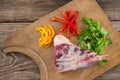 Rib chop, bell pepper and corainder leaves on wooden tray against wooden background