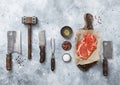 Rib eye steak with meat cleaver,fork,knife with wooden tenderizer and various herbs and oil with chopping board on light kitchen Royalty Free Stock Photo