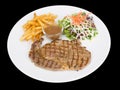 Rib eye steak served with french fries and salads to vegetables isolated on the black background with clipping path Royalty Free Stock Photo