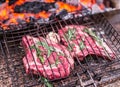 Rib eye steaks and grill with burning fire behind them. Royalty Free Stock Photo
