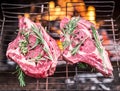 Rib eye steaks and grill with burning fire behind them. Royalty Free Stock Photo