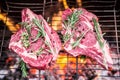 Rib eye steaks and grill with burning fire behind them Royalty Free Stock Photo