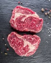 Rib eye steaks with spices on the black background. Royalty Free Stock Photo