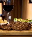 Rib eye with steamed vegetables with wooden background and wine