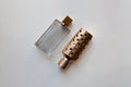 Ribbed glass and glossy golden perfume bottles on white background