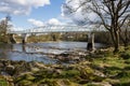 Dinkley footbridge crossing the river ribble near hurst green with rapids and rocks Royalty Free Stock Photo