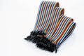 Ribbon cable or multi-wire planar cable on white background. Flat ribbon cable with pin connectors. Multi-colored ribbon computer