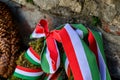 Ribbon with national colours of Hungary tied up to the flower tribute standing near to the old castle wall in Mukachevo, Ukraine.