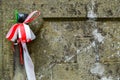 Ribbon with national colours of Poland tied up to the old gravestone on the ols cemetery. All saints day concept.