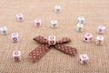 A ribbon and scattered dice-sized alphabet cubes on a textured surface Royalty Free Stock Photo