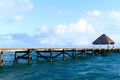 Ribbon wooden gazebo and chair on the beach at sunset or sunrise. Background of a seashore with seat, resting pavilion, palm trees