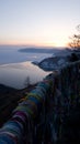 Ribbons for good luck tied on the observation platform of the Chersky stone in Listvyanka. Vertical view. Sunset in Siberia Royalty Free Stock Photo