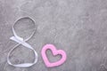 Ribbons shaped as 8 March with heart on grey. International Women`s Day Royalty Free Stock Photo