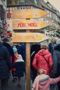 RibeauvillÃÂ©, Alsace, France - December 8, 2019: wooden signpost showing dirrection to Santa Claus PÃÂ¨re NoÃÂ«l. Big crowd on the