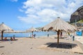 Ribeira Brava, Madeira, Portugal - Sep 9, 2019: Sandy beach in the Madeiran vacation resort. Sunbeds and umbrellas, people on the