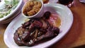 Ribeye with onions an mushrooms on top served with rice and Caesar salad