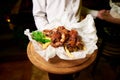 Ribs with potatoes and herbs on a wooden tray in the hand of the waiter Royalty Free Stock Photo