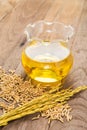 Rice bran oil in bottle glass and unmilled rice on wooden background Royalty Free Stock Photo