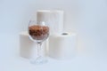 Essential goods for a coronovirus pandemic. rice and buckwheat are in a wine glass instead of wine and toilet paper rolls