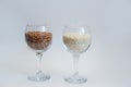 Rice and buckwheat groats stand in a wine glass on a white background