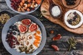 Rice coconut porridge with figs, berries, nuts, dried apricots and coconut milk in plate on rustic wooden background. Healthy Royalty Free Stock Photo