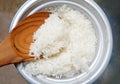 Rice cooking in electric rice cooker with steam boiled pot with wooden spoon ladle Royalty Free Stock Photo