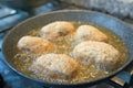 Rice croquettes frying in boiling oil