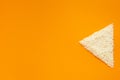Rice dietary product, source of nutrients. Groats of rice in triangle shape on orange background